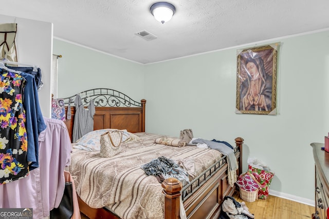 bedroom with a textured ceiling and hardwood / wood-style flooring