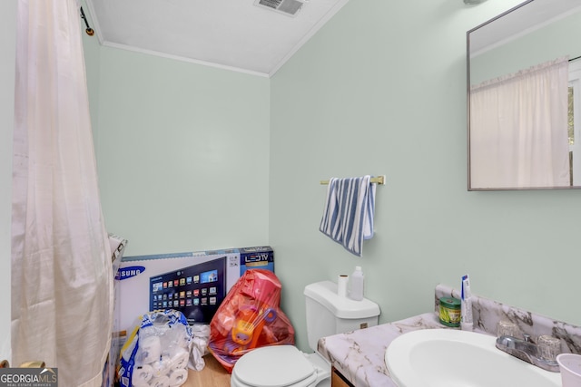 bathroom featuring vanity, toilet, and ornamental molding