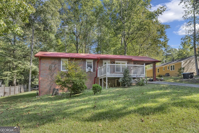 view of front of property with a deck and a front lawn