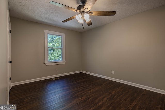 spare room with ceiling fan, a textured ceiling, and dark wood-type flooring