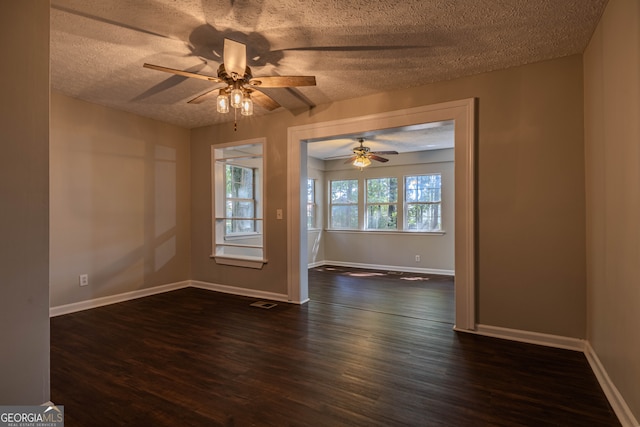 spare room featuring a textured ceiling, dark wood-type flooring, and ceiling fan