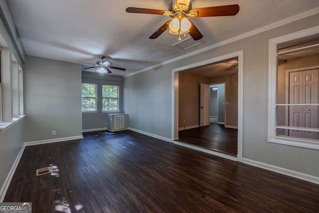 empty room featuring ceiling fan, a textured ceiling, dark hardwood / wood-style floors, and ornamental molding