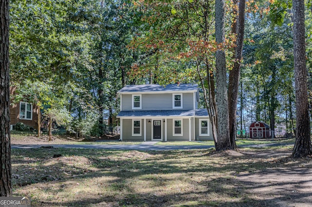 view of front property featuring a shed and a front yard