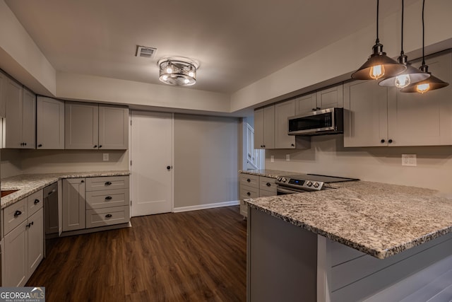 kitchen featuring dark wood-type flooring, kitchen peninsula, stainless steel appliances, decorative light fixtures, and light stone countertops