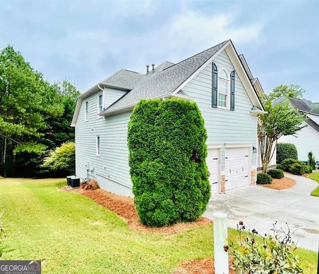 view of property exterior featuring a lawn, concrete driveway, an attached garage, and a shingled roof