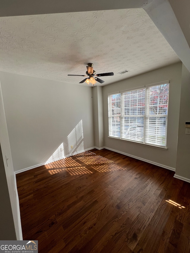 interior space with ceiling fan, dark hardwood / wood-style flooring, and a textured ceiling