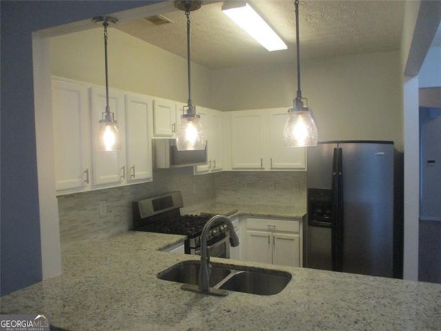 kitchen with backsplash, stainless steel appliances, white cabinetry, and sink