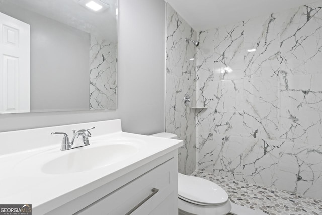 full bathroom with toilet, a marble finish shower, and vanity