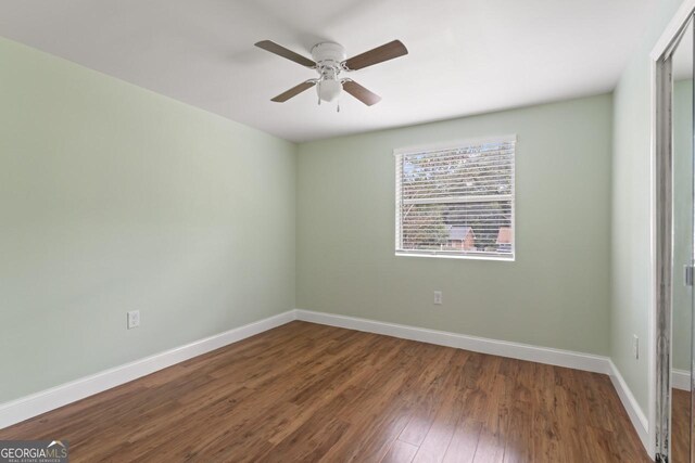 spare room with hardwood / wood-style floors and ceiling fan