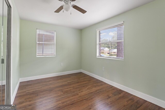 unfurnished room with ceiling fan and dark hardwood / wood-style floors