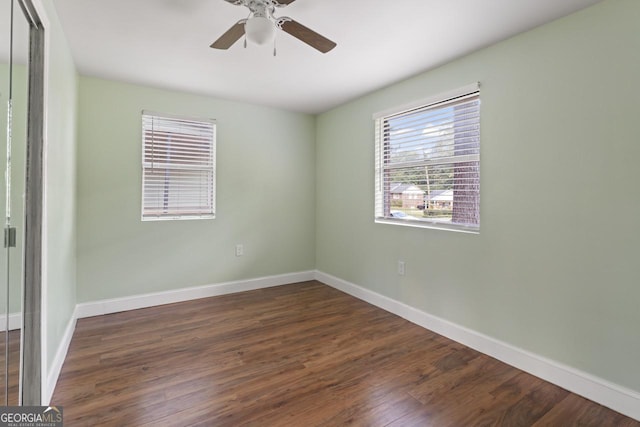 empty room featuring ceiling fan, baseboards, and wood finished floors