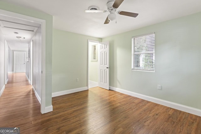 spare room with ceiling fan, wood finished floors, and baseboards