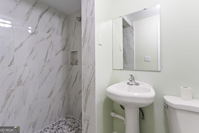 bathroom with tiled shower and toilet