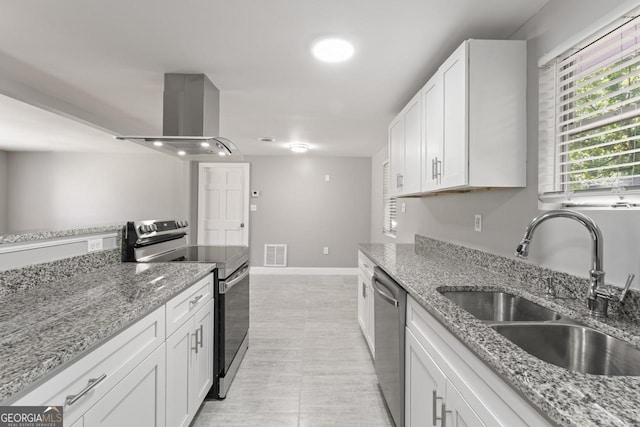 kitchen with island exhaust hood, visible vents, appliances with stainless steel finishes, white cabinetry, and a sink