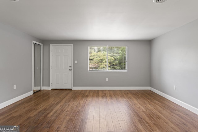 unfurnished living room with baseboards and wood finished floors