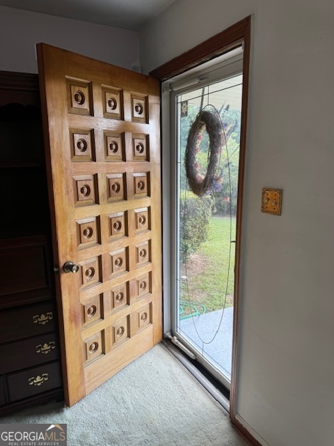 doorway to outside with plenty of natural light and carpet