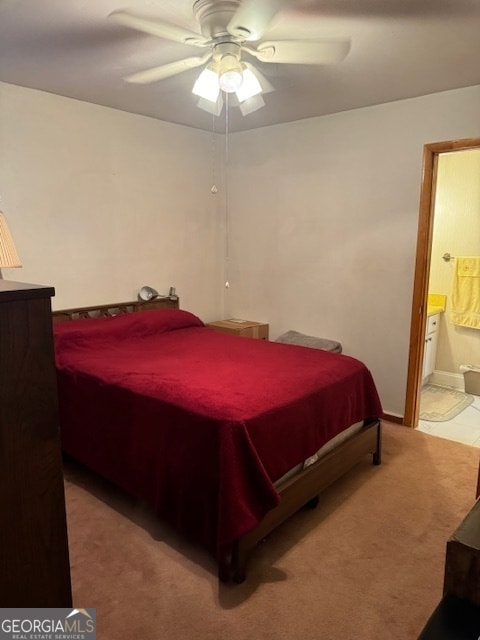 carpeted bedroom featuring ensuite bath and ceiling fan