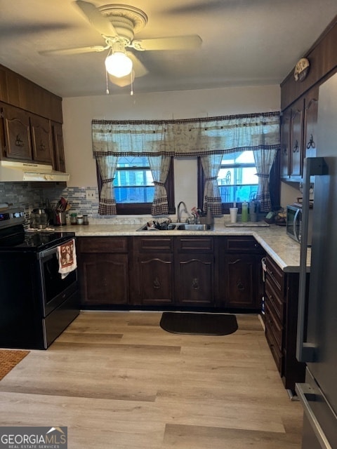 kitchen with ceiling fan, sink, light hardwood / wood-style flooring, appliances with stainless steel finishes, and decorative backsplash