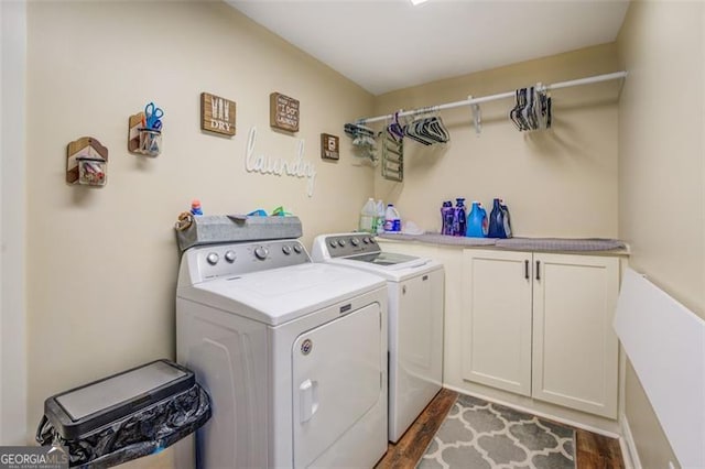 washroom featuring cabinets, dark wood-type flooring, and separate washer and dryer