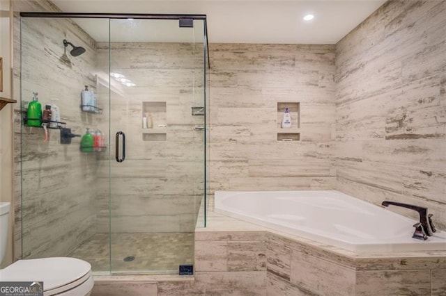 bathroom featuring separate shower and tub and toilet