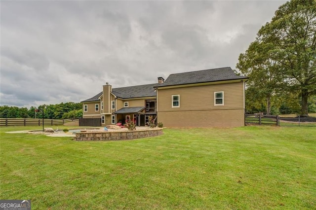 back of house featuring a lawn and a patio