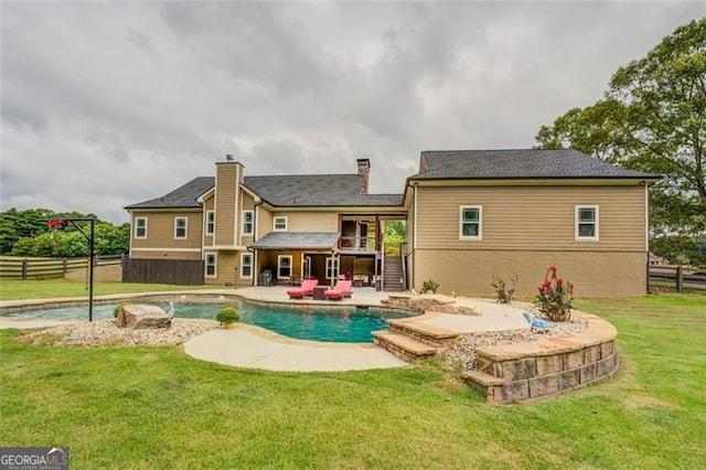 rear view of house featuring a lawn and a patio area