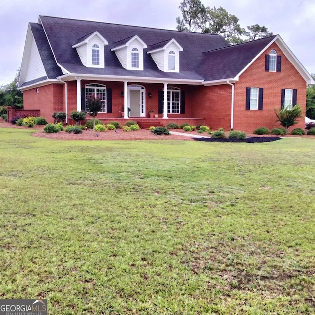 cape cod home featuring a front lawn