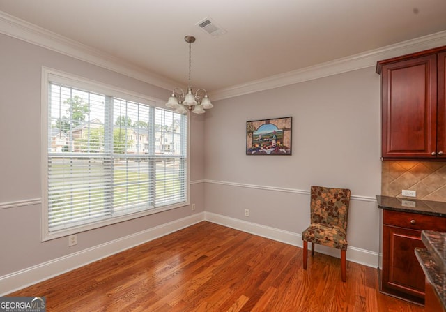 unfurnished room with a chandelier, visible vents, light wood-style flooring, and crown molding