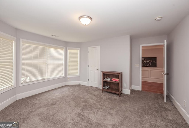 unfurnished room featuring visible vents, baseboards, and carpet flooring