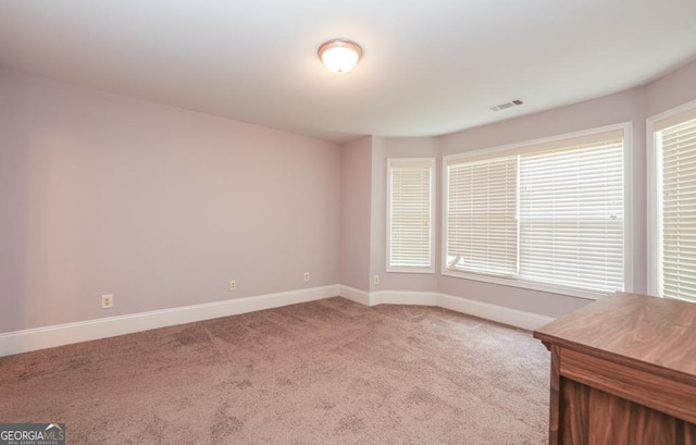 carpeted spare room with visible vents and baseboards