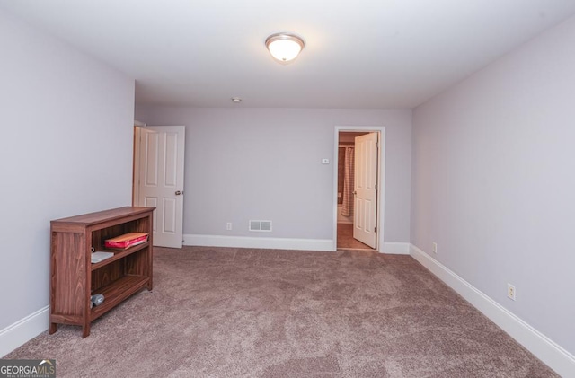 unfurnished bedroom with carpet, visible vents, and baseboards