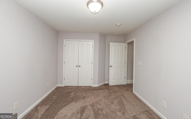 unfurnished bedroom featuring a closet, carpet, and baseboards