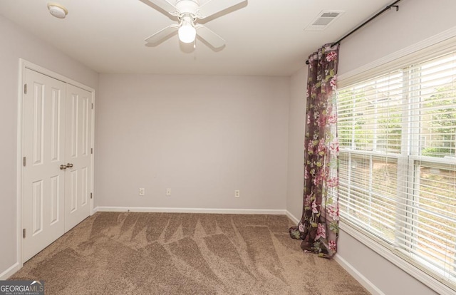 interior space featuring a ceiling fan, visible vents, and baseboards