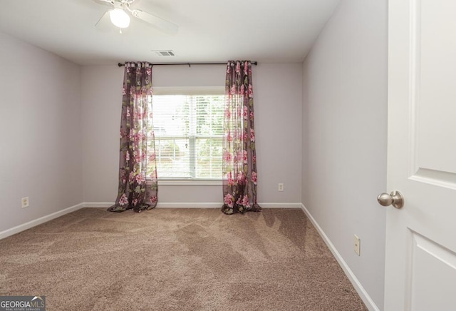 empty room featuring ceiling fan, carpet, visible vents, and baseboards