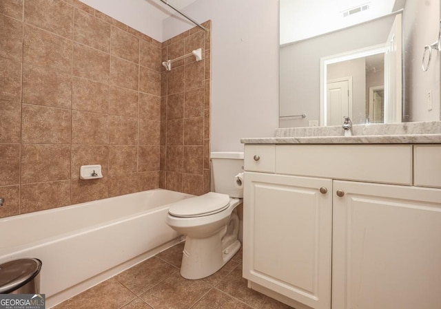 bathroom with bathing tub / shower combination, visible vents, toilet, vanity, and tile patterned floors