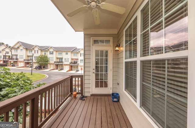 wooden terrace featuring a residential view and a ceiling fan