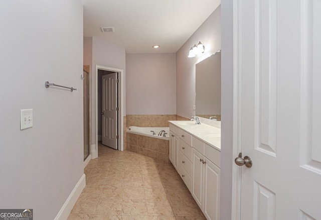 bathroom featuring a sink, double vanity, a stall shower, and a garden tub