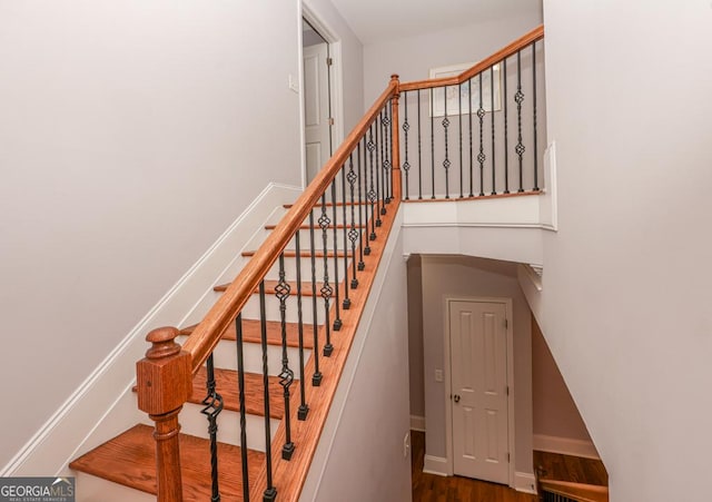 stairway with wood finished floors and baseboards