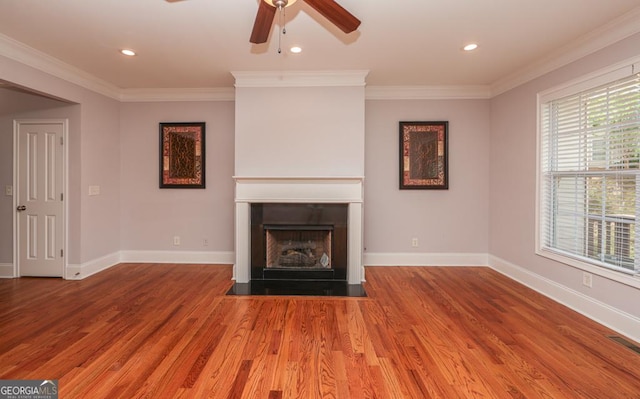 unfurnished living room with baseboards, a fireplace with flush hearth, ornamental molding, wood finished floors, and recessed lighting