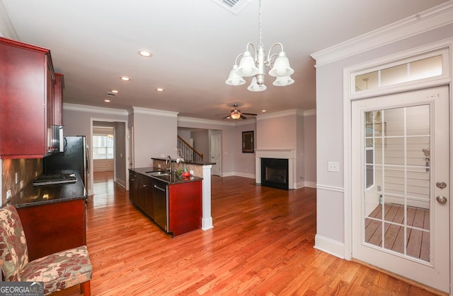 kitchen featuring dark countertops, a sink, stainless steel dishwasher, and dark brown cabinets