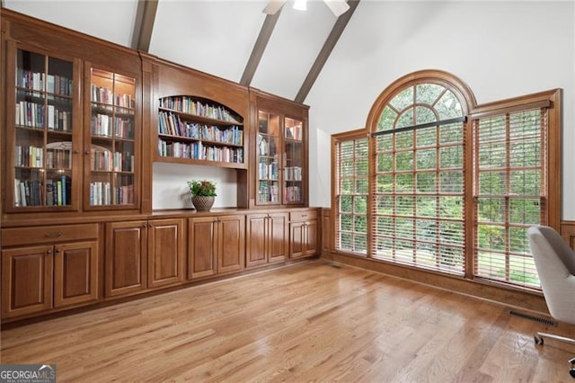 interior space featuring high vaulted ceiling, light wood-type flooring, beam ceiling, and ceiling fan