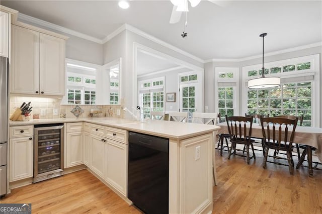 kitchen with wine cooler, kitchen peninsula, a healthy amount of sunlight, and black dishwasher