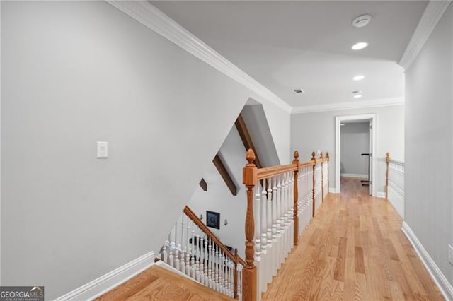 stairs with ornamental molding and hardwood / wood-style floors