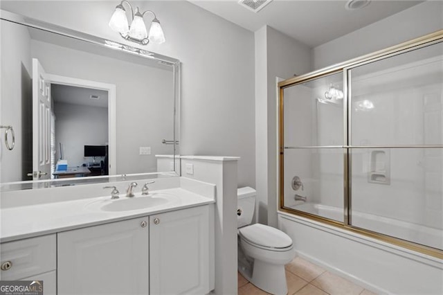 full bathroom with tile patterned flooring, a notable chandelier, bath / shower combo with glass door, vanity, and toilet