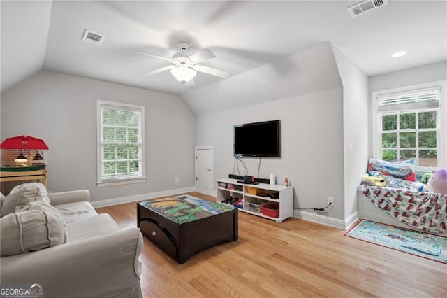 living room with light hardwood / wood-style floors, vaulted ceiling, and ceiling fan