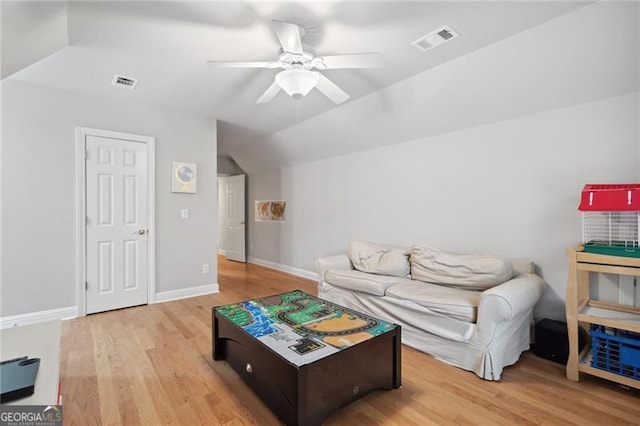 living room with light wood-type flooring, vaulted ceiling, and ceiling fan