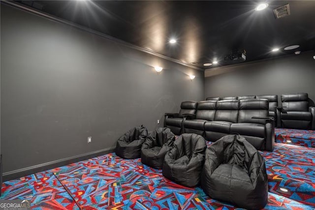 carpeted home theater room with ornamental molding