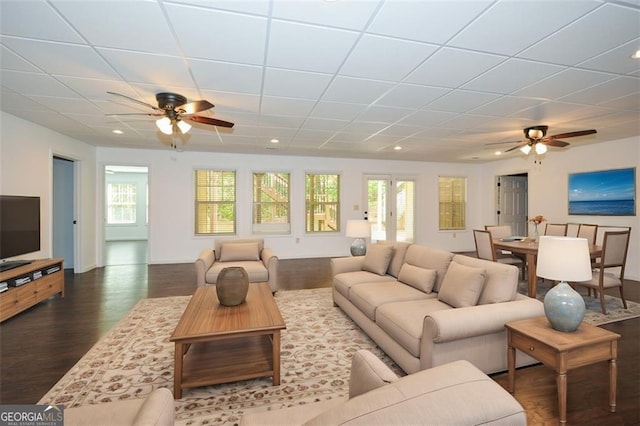 living room with ceiling fan and dark hardwood / wood-style flooring