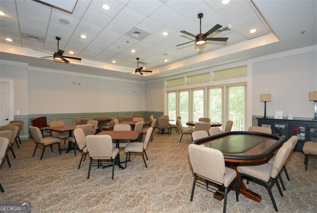 dining area featuring ceiling fan, a raised ceiling, light carpet, and crown molding