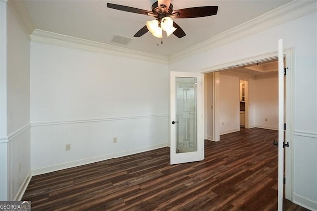 empty room featuring french doors, crown molding, ceiling fan, and dark wood-type flooring